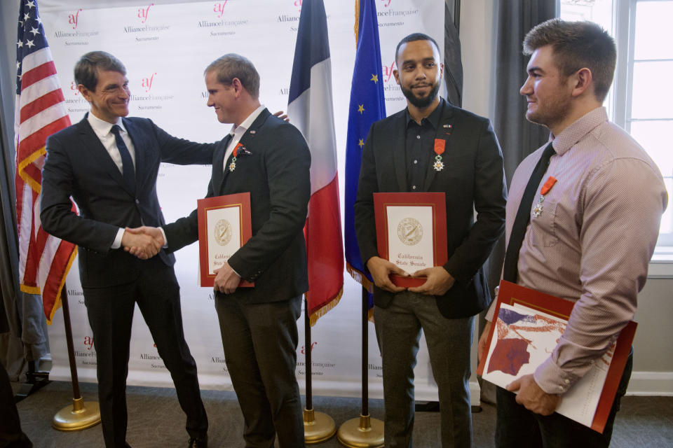 French Consul General Emmanuel Lebrun-Damiens, left, congratulates Spencer Stone, Anthony Sadler, and Alek Skarlatos during a French Naturalization Ceremony in Sacramento, Calif., Thursday, Jan. 31, 2019. The three men were heralded as heroes when they subdued an armed terrorist on a train in France in 2015. Today they were granted French citizenship. (AP Photo/Randall Benton)