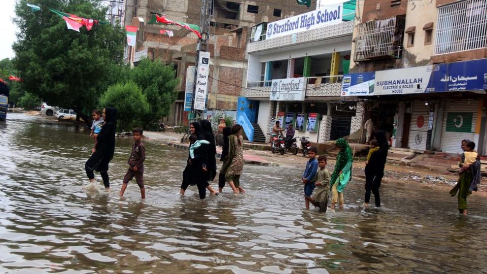卡拉奇連日降雨後，人們穿過被洪水淹沒的街道