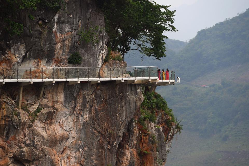 people stand on the Bach Long glass bridge in the Moc Chau district in Vietnam's Son La province