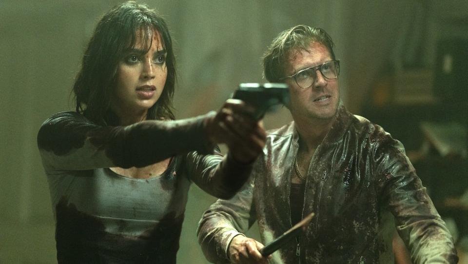 Melissa Barrera and Dan Stevens blood-soaked and holding weapons in Abigail