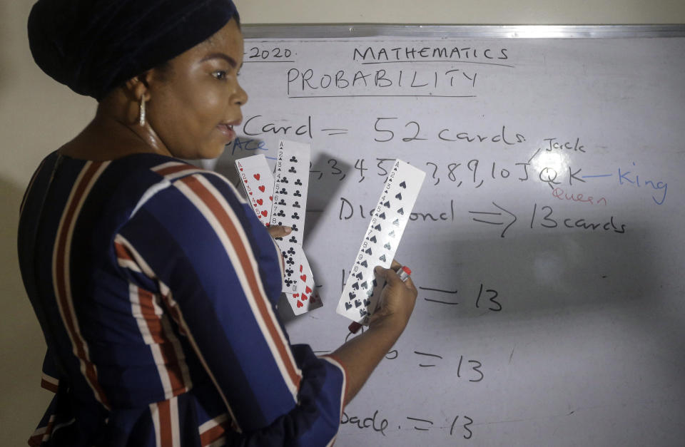 Mathematics teacher Basirat Olamide Ajayi, 36, teaches probability theory with the aid of playing cards, online via her mobile phone from her house in Lagos, Nigeria Saturday, Aug. 15, 2020. The teacher from a Lagos public school is helping students across the country, and internationally, learn math virtually during coronavirus restrictions that have prevented most children from returning to class in Nigeria. (AP Photo/Sunday Alamba)