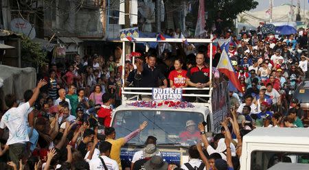 Presidential candidate Rodrigo "Digong" Duterte throws an election souvenir shirt to supporters during election campaigning for May 2016 national elections in Malabon, Metro Manila in the Philippines April 27, 2016. REUTERS/Erik De Castro