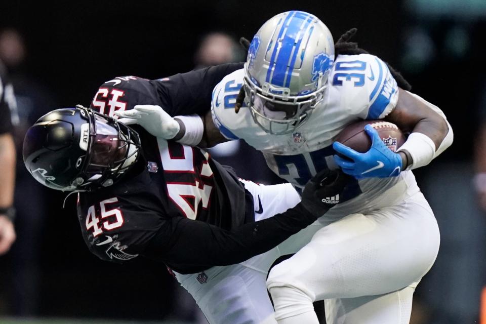 Detroit Lions running back Jamaal Williams (30) hits Atlanta Falcons inside linebacker Deion Jones (45) during the second half Sunday, Dec. 26, 2021, in Atlanta.
