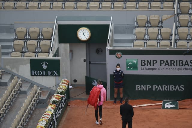 Victoria Azarenka walks out of a near-empty Suzanne Lenglen Court after her French Open first round match against Danka Kovinic is suspended because of the weather