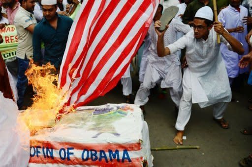 Demonstrators set fire to a mock coffin of US President Barack Obama and the US flag during a protest against satirical cartoons and an internet film mocking Islam in Dhaka