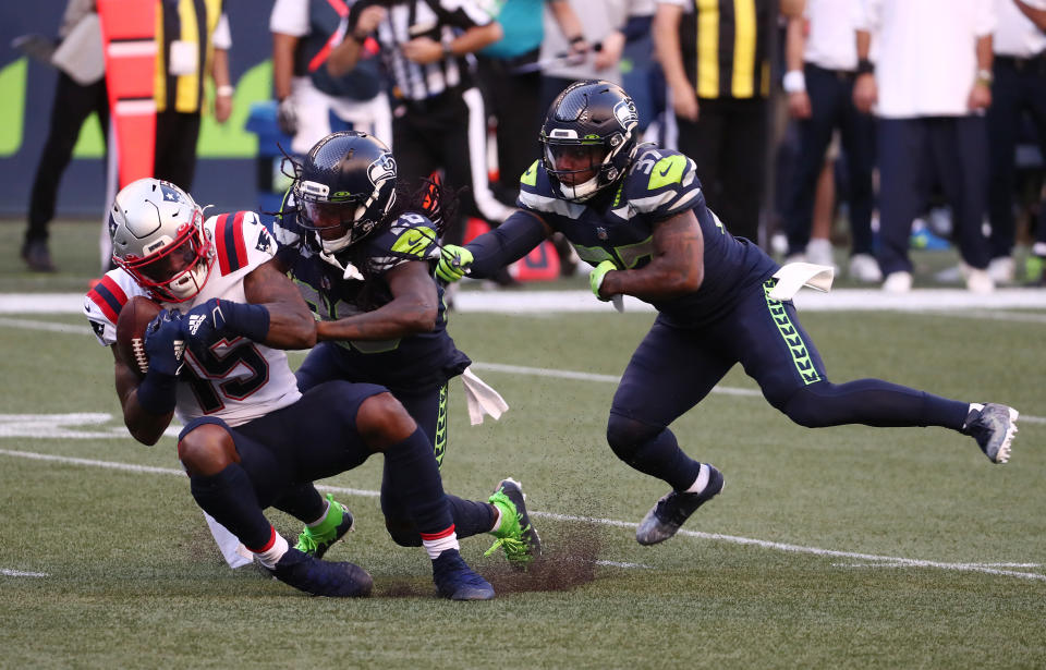 SEATTLE, WASHINGTON - SEPTEMBER 20: N'Keal Harry #15 of the New England Patriots is tackled by Shaquill Griffin #26 and Quandre Diggs #37 of the Seattle Seahawks during the first half at CenturyLink Field on September 20, 2020 in Seattle, Washington. (Photo by Abbie Parr/Getty Images)