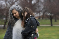 A woman and child join others gathered in front of the Patterson Park Observatory to participate in a prayer circle in honor of the victims of the collapse of the Francis Scott Key Bridge, in Baltimore, Thursday, March 28, 2024. The prayer circle was hosted by Redemption City Church. (Kaitlin Newman/The Baltimore Banner via AP)