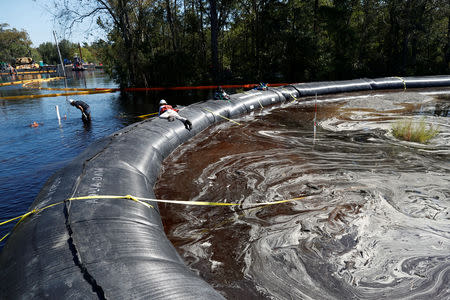 Santee Cooper workers check the water levels around a 6000 foot long Aqua Dam built to keep sediment from a coal ash retention pond from going into the flooded Waccamaw River in the aftermath of Hurricane Florence in Conway, South Carolina, U.S. September 26, 2018. REUTERS/Randall Hill
