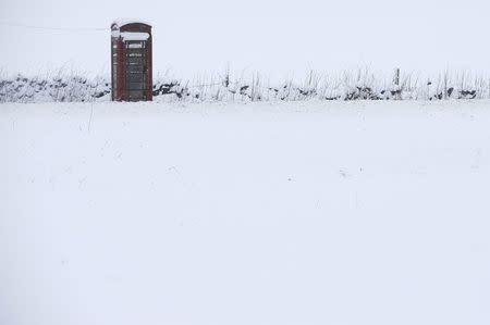 A phone box stands in snow in Newhaven, central England, January 21, 2015. REUTERS/Darren Staples/File Photo