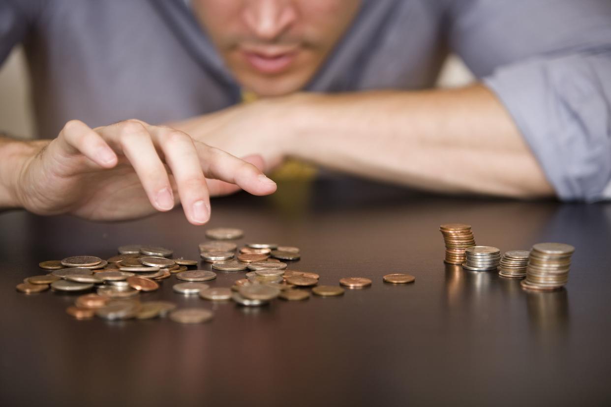 man counting or sorting American coins on table