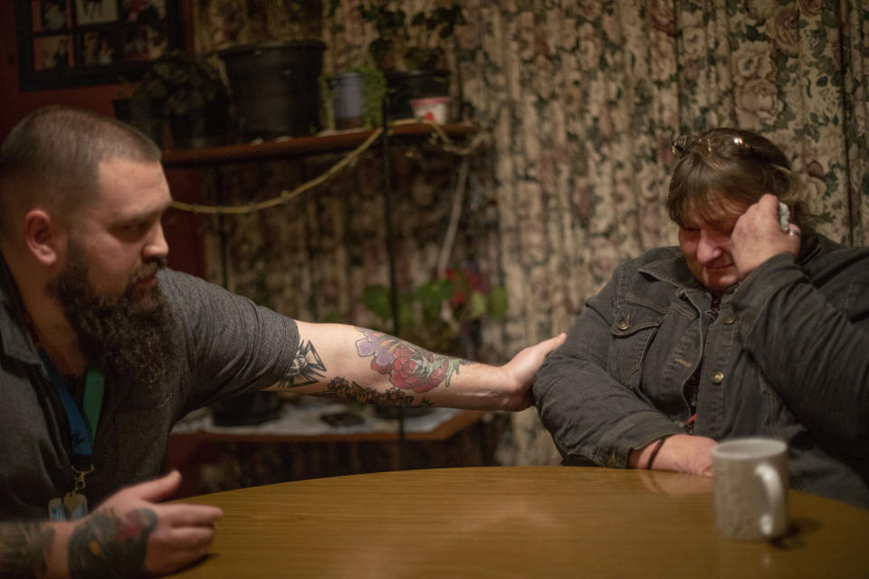 Carmall Casey, right, is comforted by friend, Jake Marshall, while visiting her at home in Black River, Tasmania, Australia, Tuesday, July 23, 2019. Marshall has helped support her through her own recovery from opioid addiction. "I became an addict without knowing," says Casey. "I became an addict with no choice." (AP Photo/David Goldman)