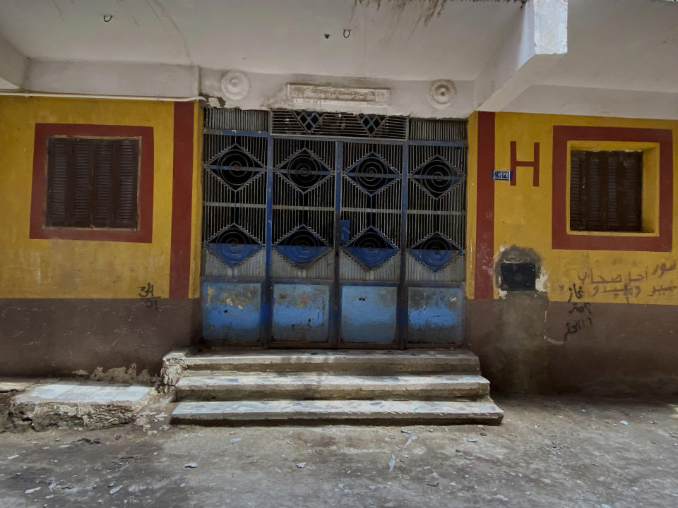 This April 17, 2020 photo, shows the closed down home of 73-year-old Ghaliya Abdel-Wahab who died from COVID-19 on April 6, 2020, on one of two streets on complete lockdown closed off by security forces for people to quarantine after her death, in Bahtim, Shubra el-Kheima neighborhood, Qalyoubiya governorate, Egypt. (AP Photo/Nariman El-Mofty)