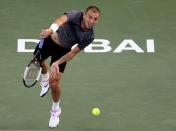 Great Britain's Daniel Evans serves to Stefanos Tsitsipas of Greece during a semi final match of the Dubai Duty Free Tennis Championship in Dubai, United Arab Emirates, Friday, Feb. 28, 2020. (AP Photo/Kamran Jebreili)