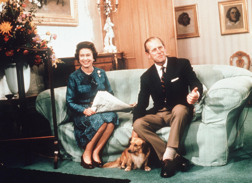 BALMORAL, SCOTLAND - 1974:  HM Queen Elizabeth II and Prince Philip, Duke of Edinburgh relax with their corgis and a newspaper at Balmoral Castle in 1974 in Balmoral, Scotland. (Photo by Anwar Hussein/Getty Images)  