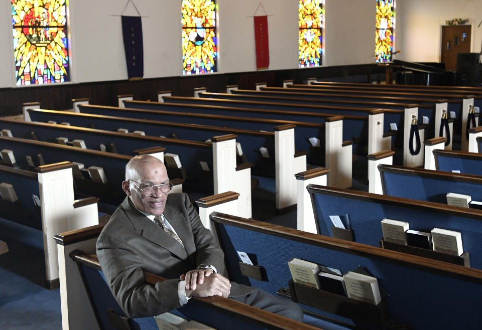 FILE - In this Thursday, March 19, 2020 file photo, the Rev. Alvin J. Gwynn Sr., of Friendship Baptist Church in Baltimore, sits for a portrait in his church. At the mostly African American congregation, Gwynn has held in-person services throughout the pandemic, but attendance hasn't risen much above 80 people — a small fraction of normal. (AP Photo/Steve Ruark)