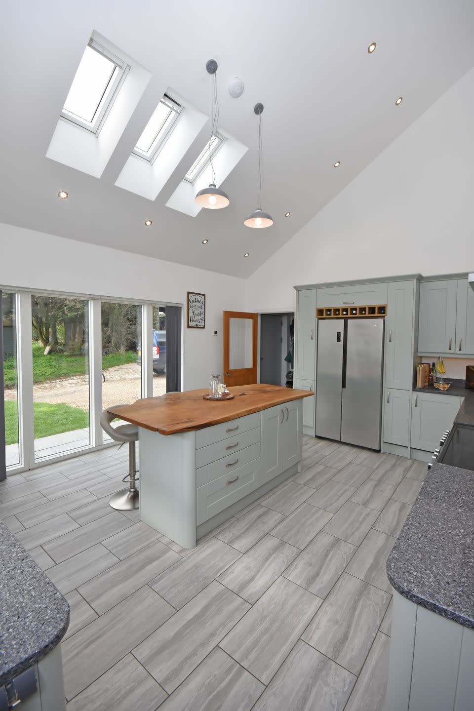 a grey kitchen with a bar and a table