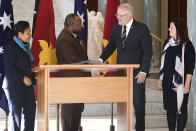 Papua New Guinea's Prime Minister James Marape, second from left, shakes hands with Australian Prime Minister Scott Morrison, watched by their respective wives Rachael Marape, left, and Jenny Morrison after signing the visitors' book at Australia's Parliament House in Canberra Monday, July 22, 2019. Marape says his country's relationship with China in not open to discussion during his current visit to Australia. (AP Photograph/Rod McGuirk)