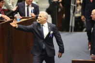 Israeli outgoing Prime Minister Yair Lapid shakes hands during the swearing-in ceremony for Israeli lawmakers at the Knesset, Israel's parliament, in Jerusalem, Tuesday, Nov. 15, 2022. Israeli lawmakers were sworn in at the Knesset, on Tuesday, following national elections earlier this month. (Abir Sultan/Pool Photo via AP)