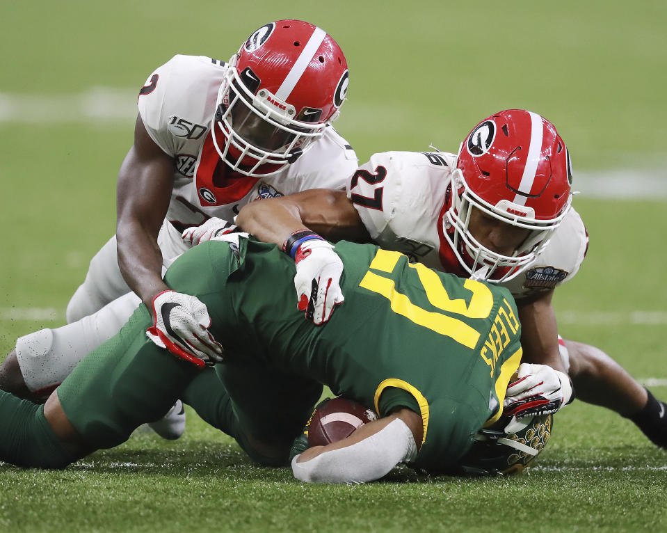 Georgia defensive backs Richard LeCounte, left, and Eric Stokes, right, take down Baylor wide receiver Josh Fleeks during the second half in the Sugar Bowl NCAA college football game at the Superdome on Wednesday, January 1, 2020, in New Orleans. (Curtis Compton/Atlanta Journal-Constitution via AP)