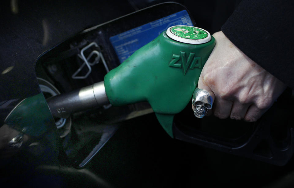 A woman fuels her car at a petrol station in London January 3, 2011. Britain's road users are facing rises in driving costs due to duty and VAT increases which take effect this week on the sale of fuel. REUTERS/Suzanne Plunkett  (BRITAIN - Tags: BUSINESS ENVIRONMENT POLITICS ENERGY)