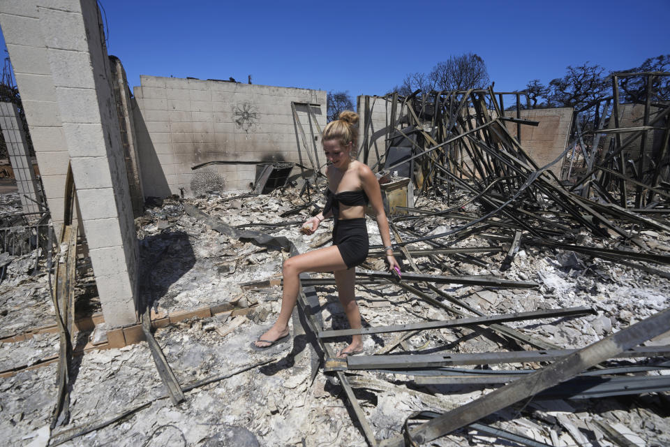 Sydney Carney walks through her home, which was destroyed by a wildfire, Friday, Aug. 11, 2023, in Lahaina, Hawaii. (AP Photo/Rick Bowmer)