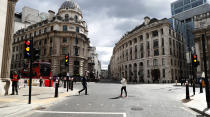 People cross the road at Bank junction in the City of London, Tuesday, April 6, 2021. When the pandemic struck, about 540,000 workers vanished from London's financial hub almost overnight. A year on, most haven't returned to the business hub. (AP Photo/Alastair Grant)