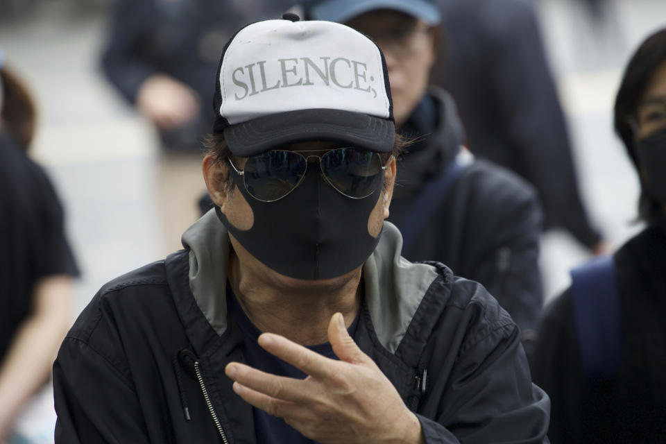 A masked man argues with police ahead of a rally demanding electoral democracy and call for boycott of the Chinese Communist Party and all businesses seen to support it in Hong Kong, Sunday, Jan. 19, 2020. Hong Kong has been wracked by often violent anti-government protests since June, although they have diminished considerably in scale following a landslide win by opposition candidates in races for district councilors late last year. (AP Photo/Ng Han Guan)