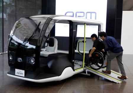 An employee of Toyota Motor Corp. demonstrates APM, a mobility vehicle designed expressly for use at the Tokyo 2020 Olympic and Paralympic Games, during a press preview in Tokyo