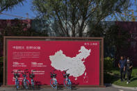 People walk by a map showing Evergrande development projects in China at an Evergrande new housing development in Beijing on Sept. 22, 2021. China’s central bank expanded the supply of money for lending Monday, Dec. 6, 2021, as Beijing tried to reassure its public and investors the economy can be protected if a troubled real estate developer’s $310 billion mountain of debt collapses. (AP Photo/Andy Wong)