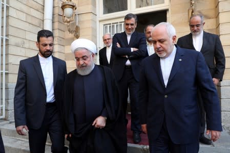 Iranian President Hassan Rouhani walks with Iran's Foreign Minister Mohammad Javad Zarif after a meeting in Tehran