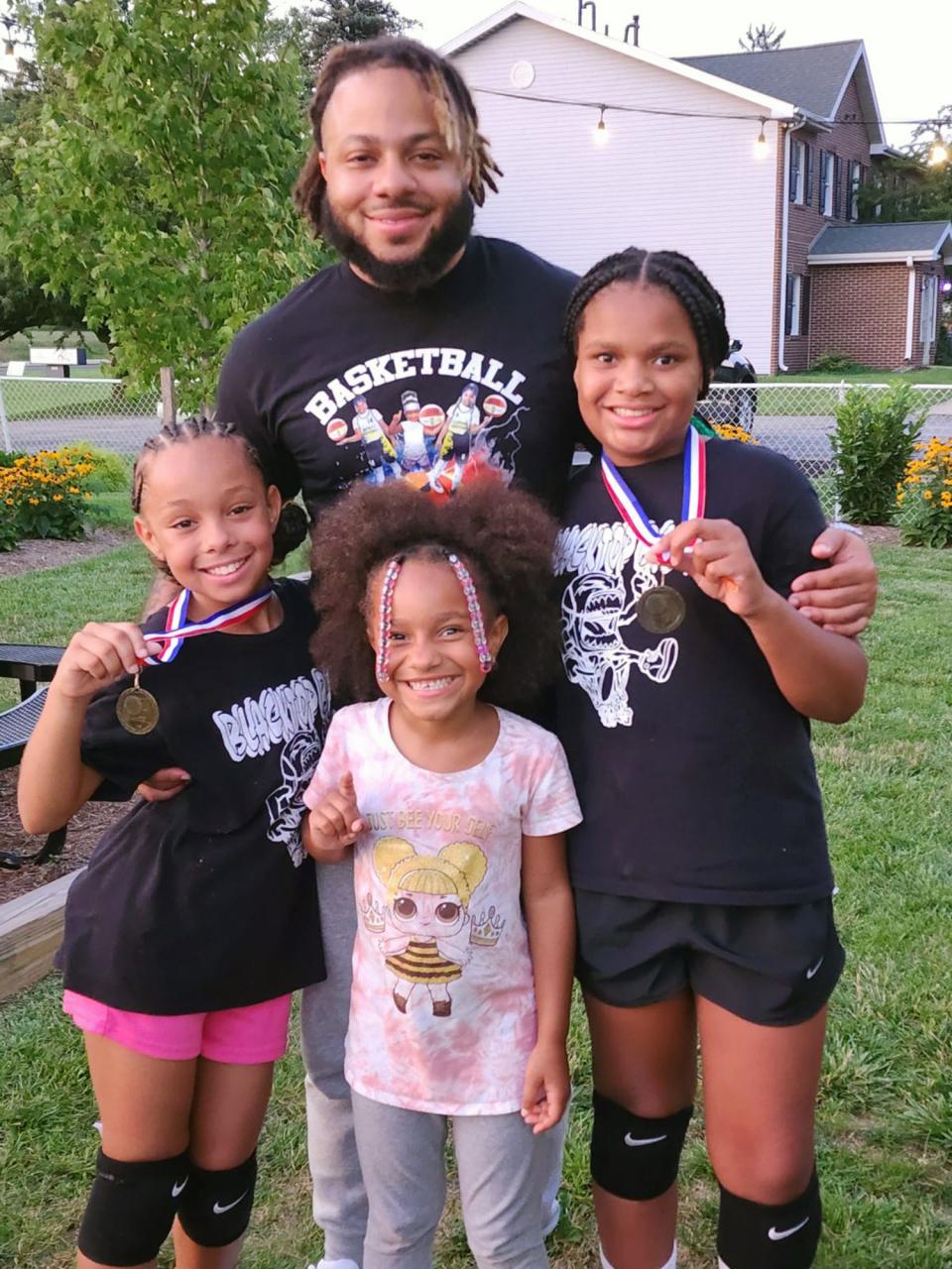 From the left, standing with their father Nathan Fleming is Nathaliz, age 10, Olivia, age 6, and Za'Miya, age 10. 