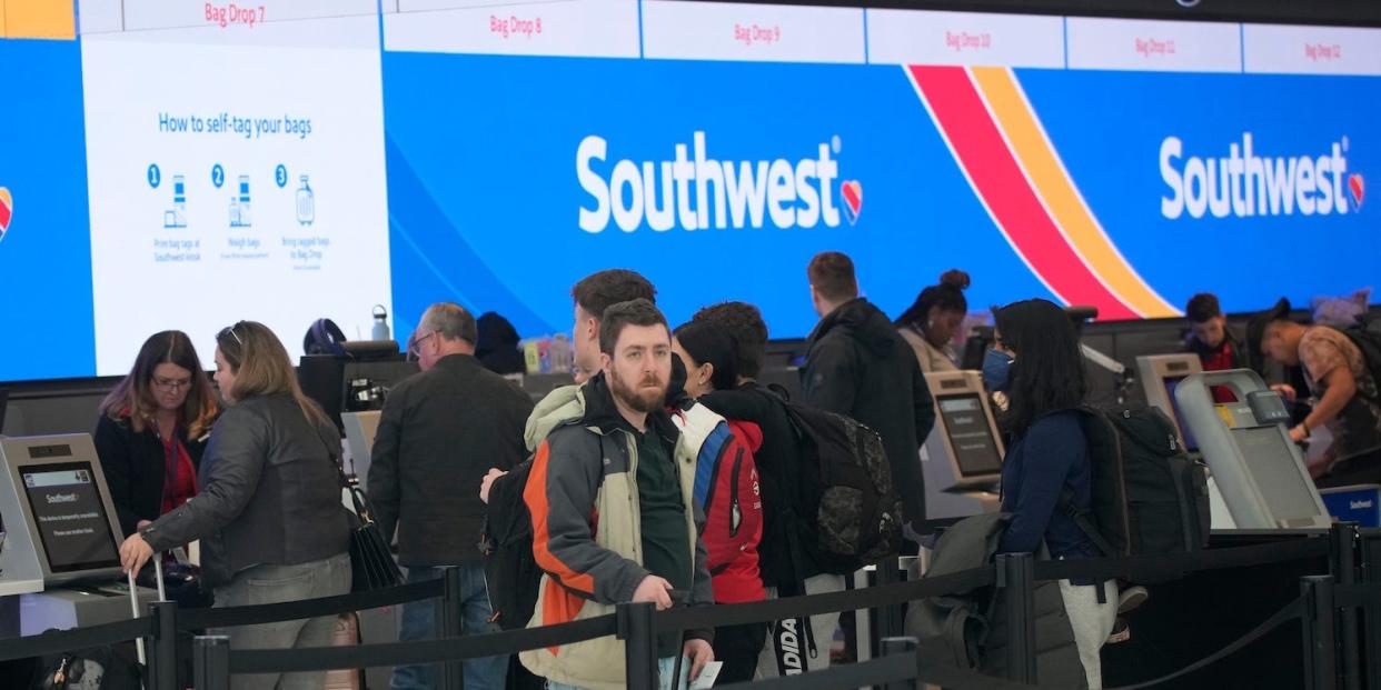 Travelers queue up at the check-in counters for Southwest Airlines in Denver International Airport, Friday, Dec. 30, 2022, in Denver.