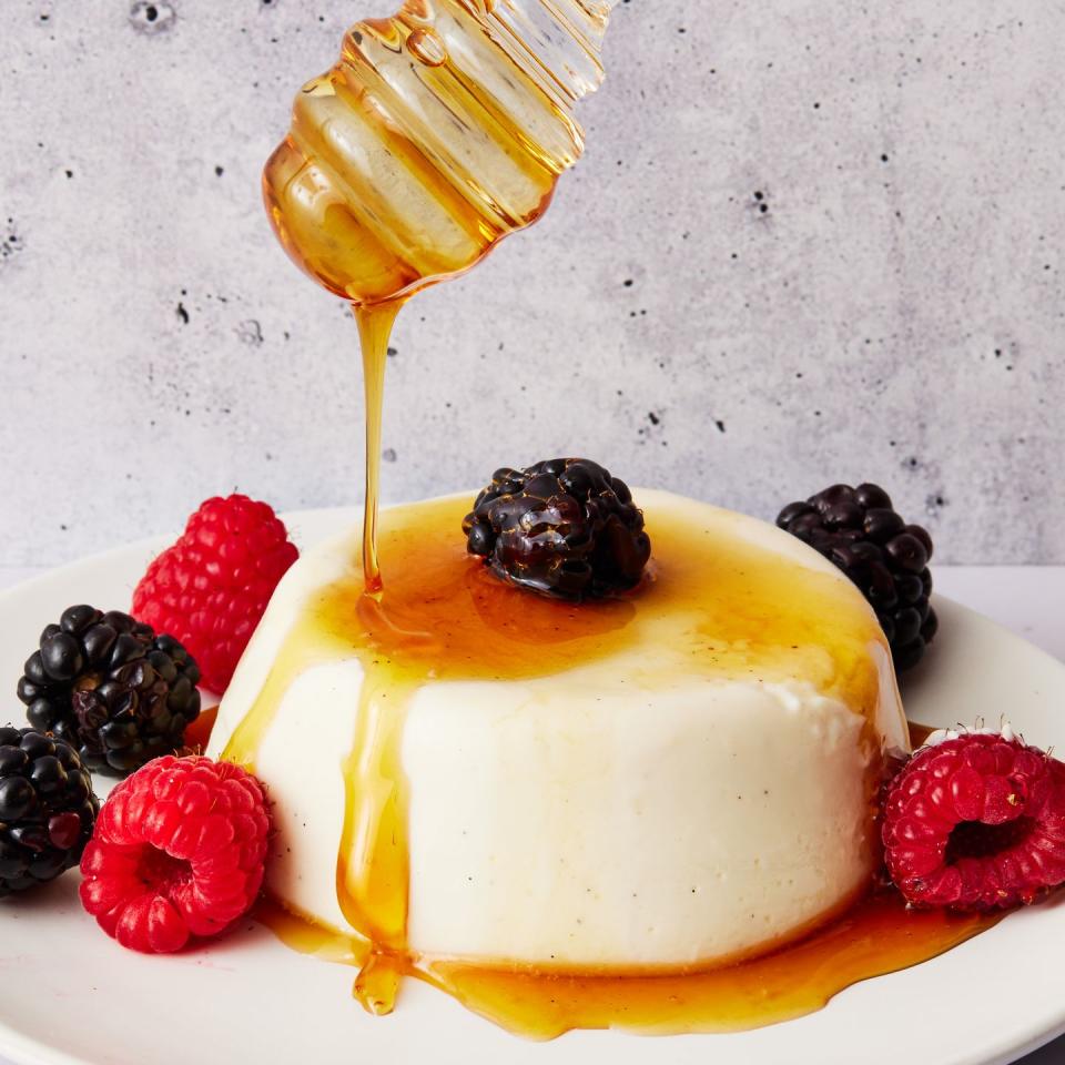 greek yogurt panna cotta topped with honey, raspberries, and blackberries