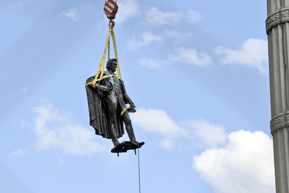 A statue of former U.S. vice president and slavery advocate John C. Calhoun is raised by crews after its removal from a 100-foot-tall monument on Wednesday, June 24, 2020, in Charleston, S.C.(AP Photo/Meg Kinnard)