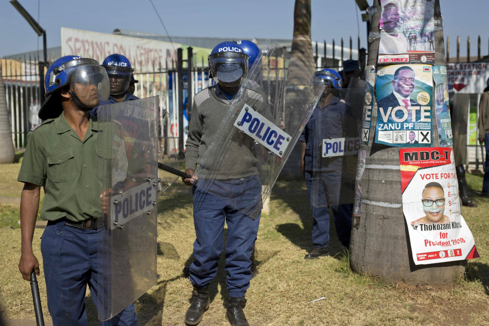 Riot police outside the Bronte hotel, where a press conference by opposition leader Nelson Chamisa was scheduled to take place, in Harare, Zimbabwe, Friday Aug. 3, 2018. Hours after President Emmerson Mnangagwa was declared the winner of a tight election, riot police disrupted a press conference where opposition leader Nelson Chamisa was about to respond to the election results. (AP Photo/Jerome Delay)