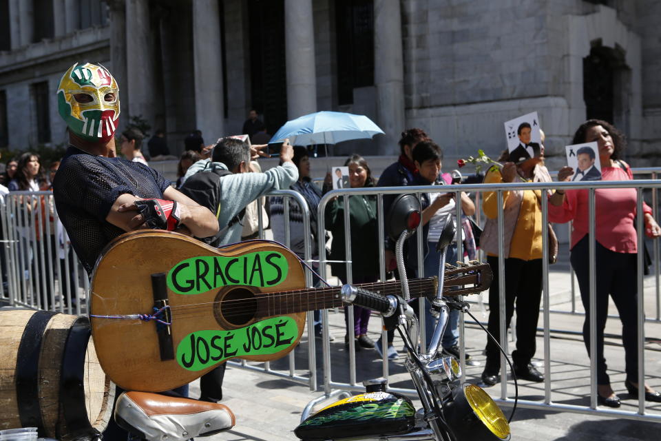 Miguel Belmont wears a wrestler’s mask as he stands outside to the Palace of Fine Arts to say farewell to Mexican singer Jose Jose, in Mexico City, Wednesday, Oct 9, 2019. Jose Jose died Sept. 28 in South Florida. His body was cremated in Miami, and after a dispute among relatives over his remains, it was agreed that half the ashes would remain there and the other half would be brought to Mexico. (AP Photo/Ginnette Riquelme)