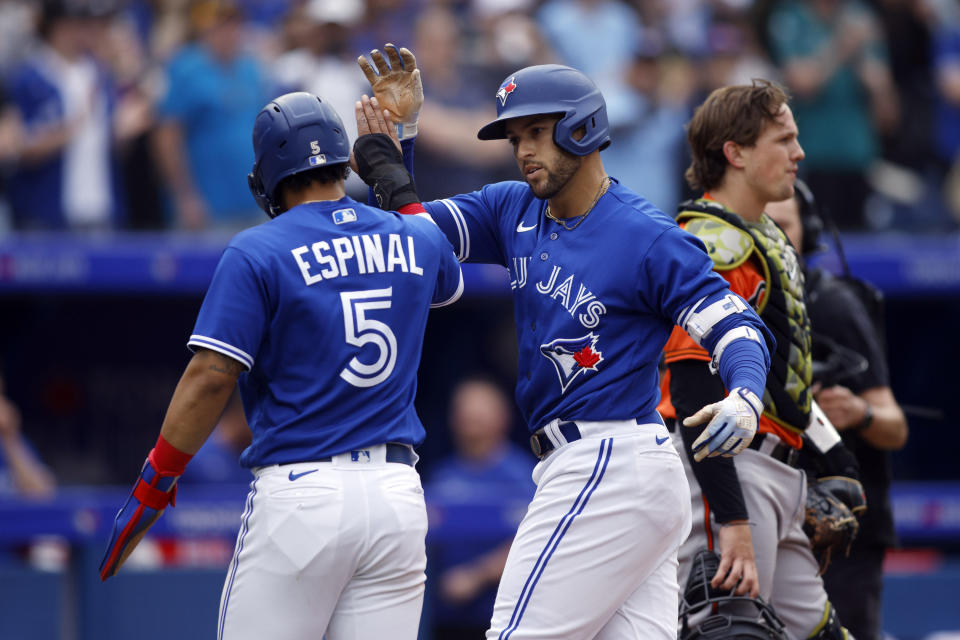 Toronto Blue Jays' George Springer (4) and celebrates with Santiago Espinal (5) after hitting a two-run home run in the fifth inning of a baseball game against the Baltimore Orioles in Toronto, Saturday, May 20, 2023. (Cole Burston/The Canadian Press via AP)