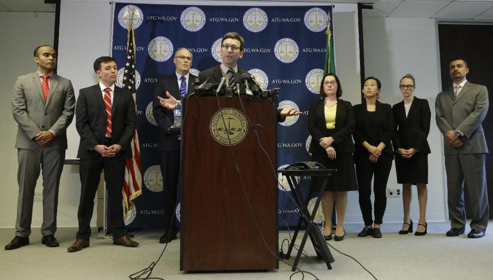 Washington Attorney General Bob Ferguson, center, talks to reporters, Monday, Jan. 30, 2017, in Seattle. Ferguson announced that he is suing President Donald Trump over an executive order that suspended immigration from seven countries with majority-Muslim populations and sparked nationwide protests. (AP Photo/Ted S. Warren)