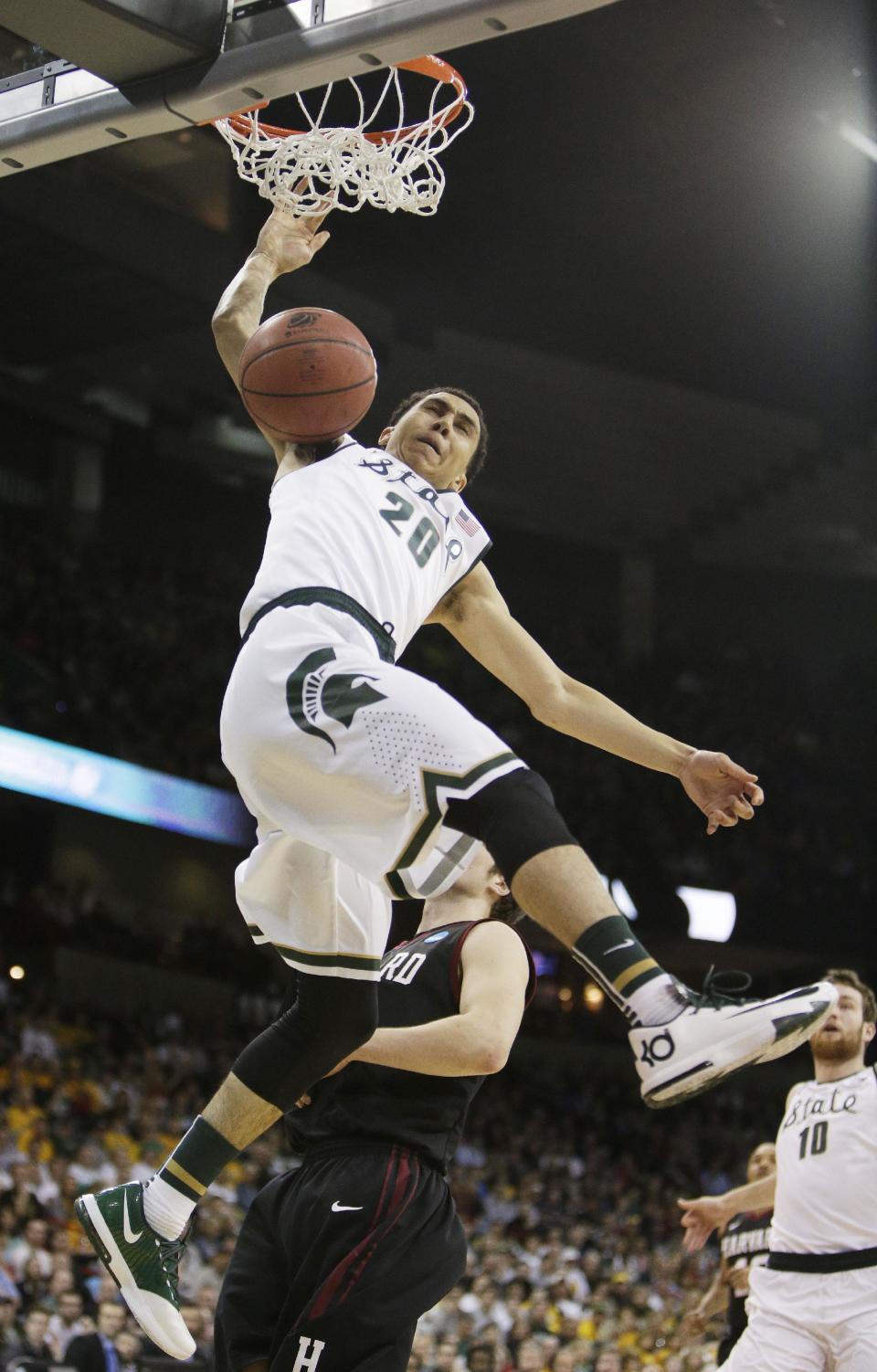 Michigan State’s Travis Trice (20) dunks in the first half during the third-round game of the NCAA men's college basketball tournament against Harvard in Spokane, Wash., Saturday, March 22, 2014. (AP Photo/Young Kwak)