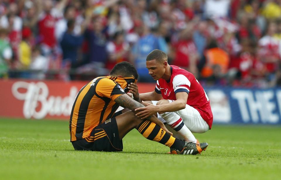 Arsenal's Kieran Gibbs (R) consoles Hull City's Tom Huddlestone, following Arsenal's victory in the FA Cup final soccer match at Wembley Stadium in London, May 17, 2014. REUTERS/Eddie Keogh (BRITAIN - Tags: SPORT SOCCER TPX IMAGES OF THE DAY)