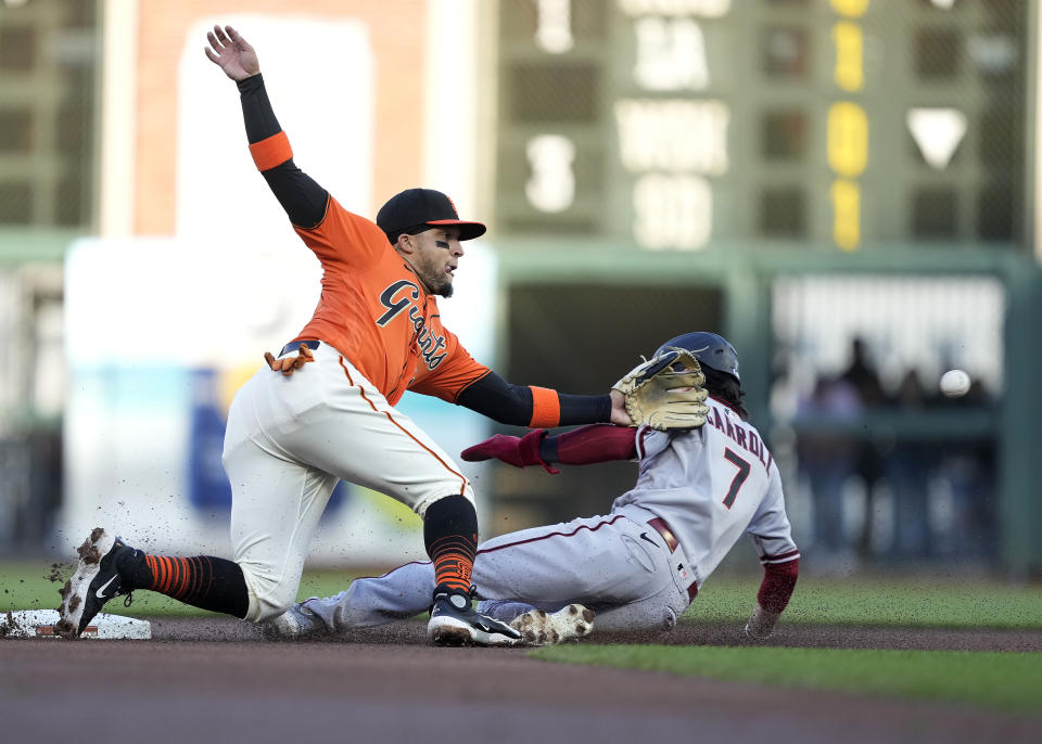 Arizona Diamondbacks' Corbin Carroll (7) beats the throw to San Francisco Giants second baseman Isan Diaz, left, to steal second base during the first inning of a baseball game in San Francisco, Friday, June 23, 2023. (AP Photo/Tony Avelar)