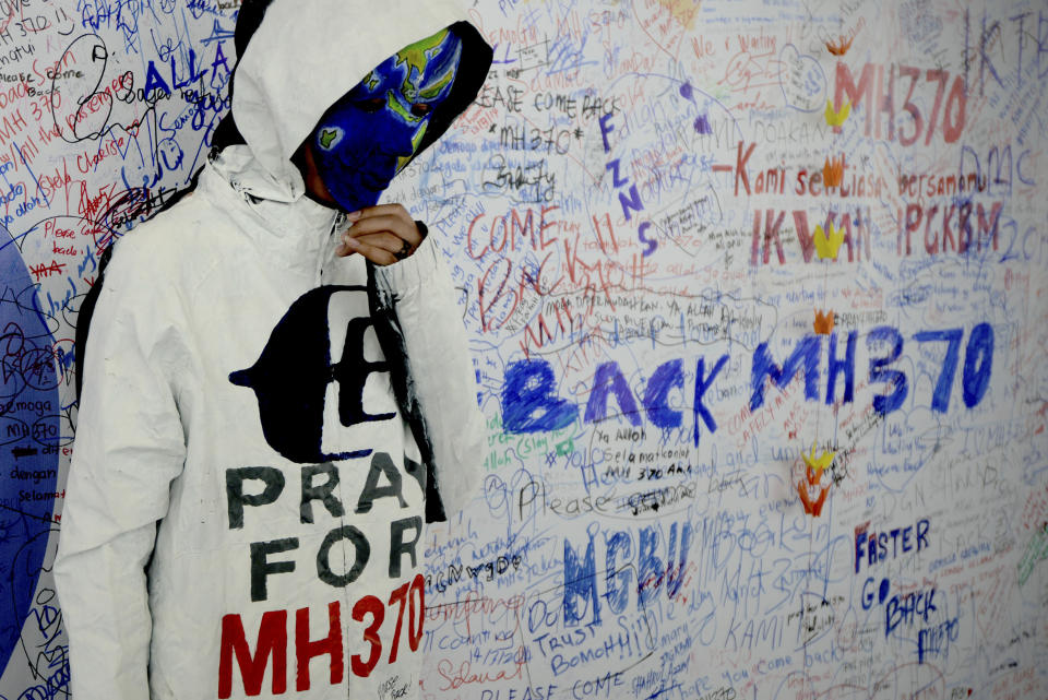 An unidentified woman with her face painted, depicting the flight of the missing Malaysia Airline, MH370, poses in front of the "wall of hope" at Kuala Lumpur International Airport in Sepang, Malaysia, Monday, March 17, 2014. Authorities now believe someone on board the Boeing 777 shut down part of the aircraft's messaging system about the same time the plane with 239 people on board disappeared from civilian radar. But an Inmarsat satellite was able to automatically connect with a portion of the messaging system that remained in operation, similar to a phone call that just rings because no one is on the other end to pick it up and provide information. No location information was exchanged, but the satellite continued to identify the plane once an hour for four to five hours after it disappeared from radar screens. (AP Photo/Joshua Paul)