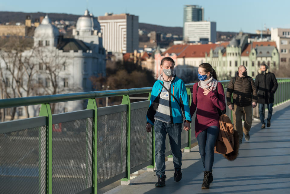 A young couple wearing face masks as a preventive measure against the spread of coronavirus walks along the Old Bridge in Bratislava. The lockdown declared by the government will last until 7th of February. (Photo by Tomas Tkacik / SOPA Images/Sipa USA)