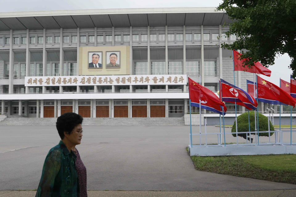 North Korean and Chinese national flags are hoisted on a street in Pyongyang, North Korea Thursday, June 20, 2019. Chinese President Xi Jinping arrived Thursday morning for a two-day state visit to North Korea, where he is expected to talk with leader Kim Jong Un about the stalled negotiations with Washington over North Korea's nuclear weapons. The sign on the building reads "The great Comrades Kim Il Sung and Kim Jong Il are forever with us." (AP Photo/Jon Chol Jin)