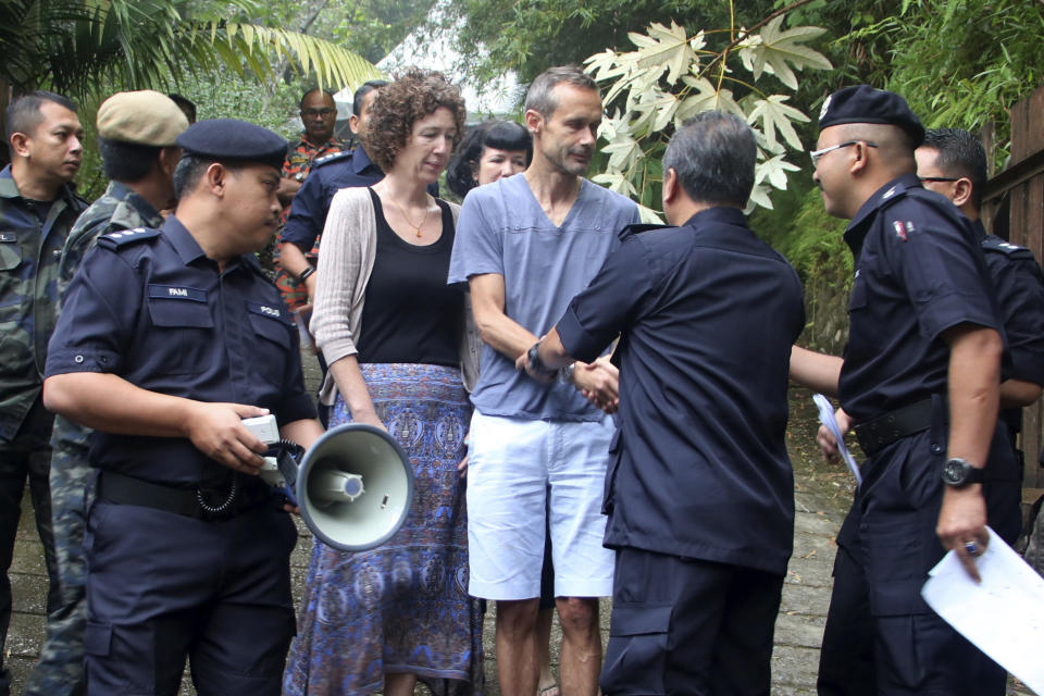 Sebastien Quoirin, center, the father of a missing British girl Nora Anne Quoirin, shakes hand with police officers as mother Meabh Quoirin, center left, stands beside him, in Seremban, Negeri Sembilan, Malaysia, Saturday, Aug. 10, 2019. The parents of the 15-year-old London girl who disappeared from a Malaysian resort a week ago say she isn't independent and has difficulty walking, in new details to support their conviction that she was abducted. (The Royal Malaysia Police via AP)