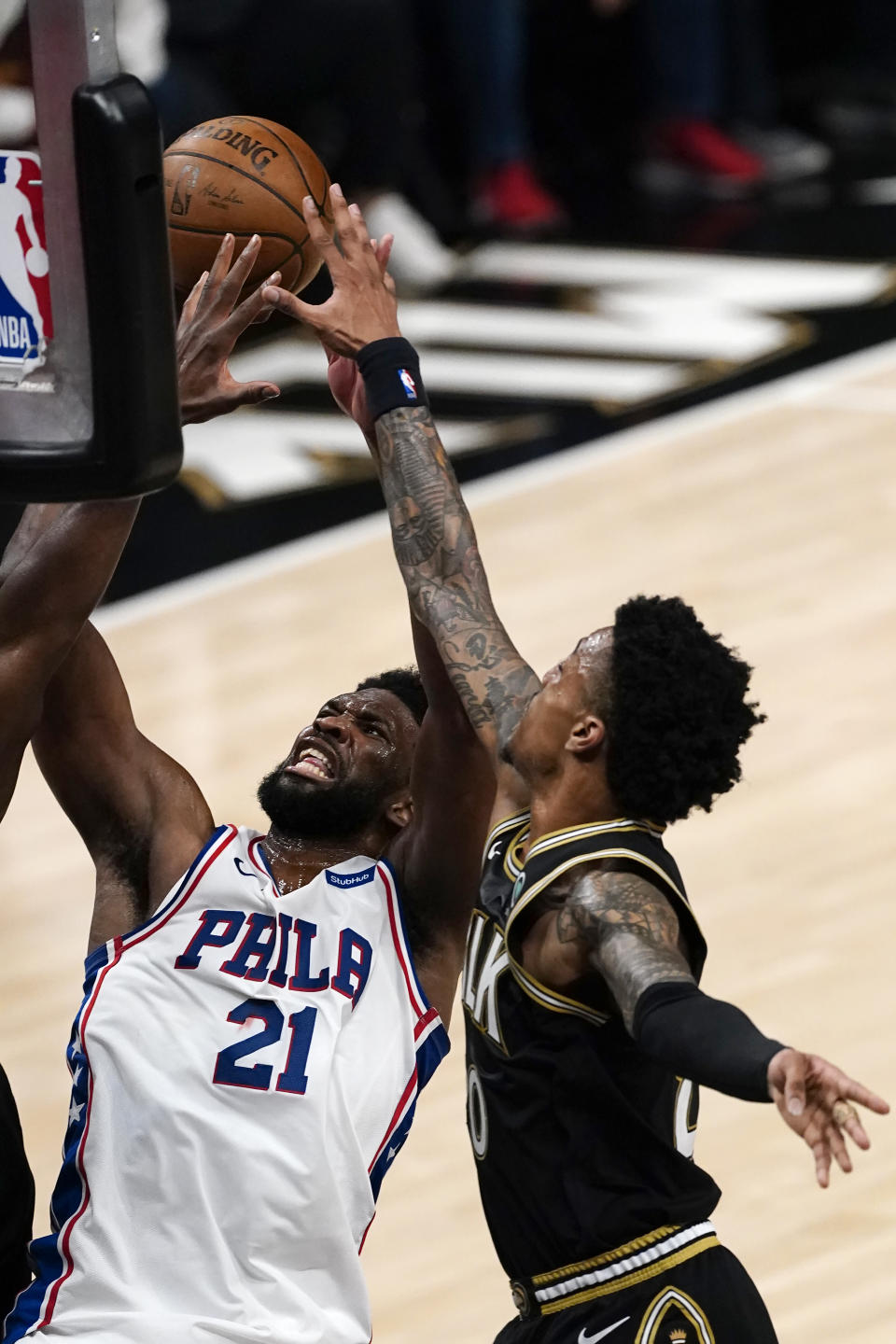 Philadelphia 76ers center Joel Embiid (21) battles Atlanta Hawks forward John Collins, right, as he goes up for a basket during the first half of Game 6 of an NBA basketball Eastern Conference semifinal series Friday, June 18, 2021, in Atlanta. (AP Photo/John Bazemore)