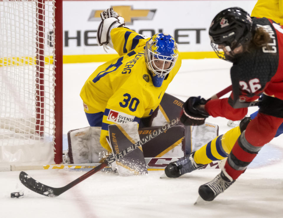 Sweden goaltender Emma Soderberg (30) makes a save against Canada forward Emily Clark (26) during the second period of a quarterfinal match at the women's world hockey championships in Brampton, Ontario, Thursday, April 13, 2023. (Frank Gunn/The Canadian Press via AP)