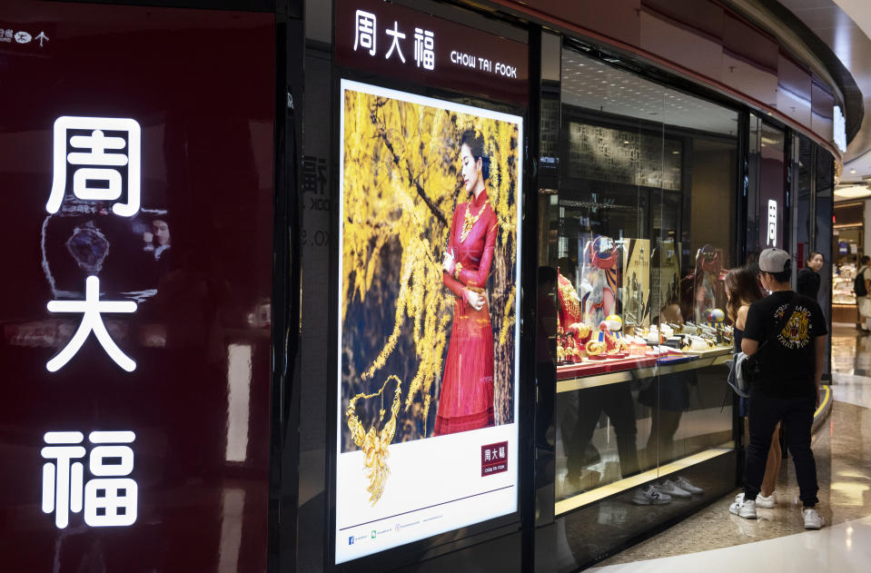 HONG KONG - 2019/04/08: A couple seen standing next to a window display of jewellery Chow Tai Fook chain store at Mong Kok shopping mall in Hong Kong. (Photo by Budrul Chukrut/SOPA Images/LightRocket via Getty Images)