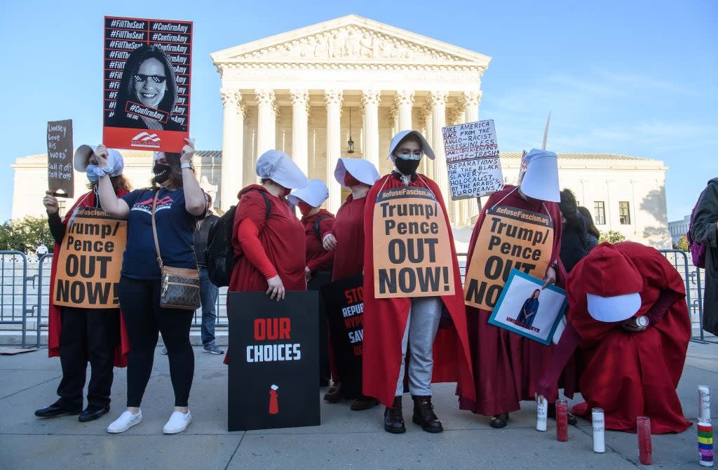 <p>Protesters dressed in ‘The Handmaid’s Tale’-inspired costumes demonstrate outside the US Supreme Court on Capitol Hill in October, 2020</p> (AFP via Getty Images)