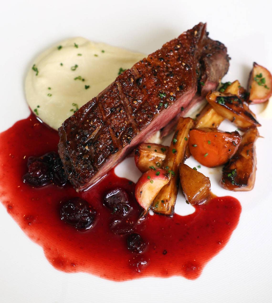 Pan-seared duck with glazed root vegetable, parsnip purée, and cranberry gastrique at Wicked Butcher at The Sinclair in downtown Fort Worth.